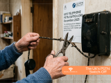 Hands cutting a vintage telephone cord with scissors next to a GPO PSTN switch-off poster and old wall connection box.