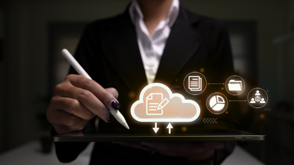 A professional in a suit uses a stylus on a tablet, with glowing digital icons representing cloud computing, document editing, data analytics, and team collaboration floating above the screen.